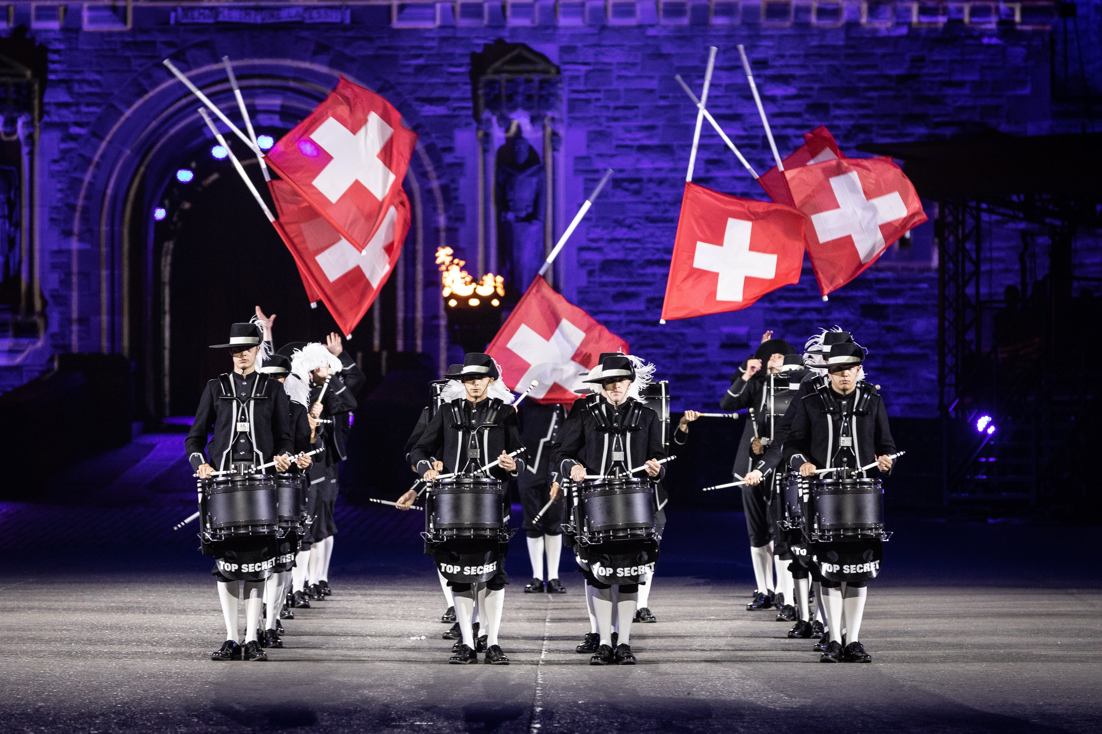Image shows drummers perform with Switzerland flags outside Edinburgh Castle.